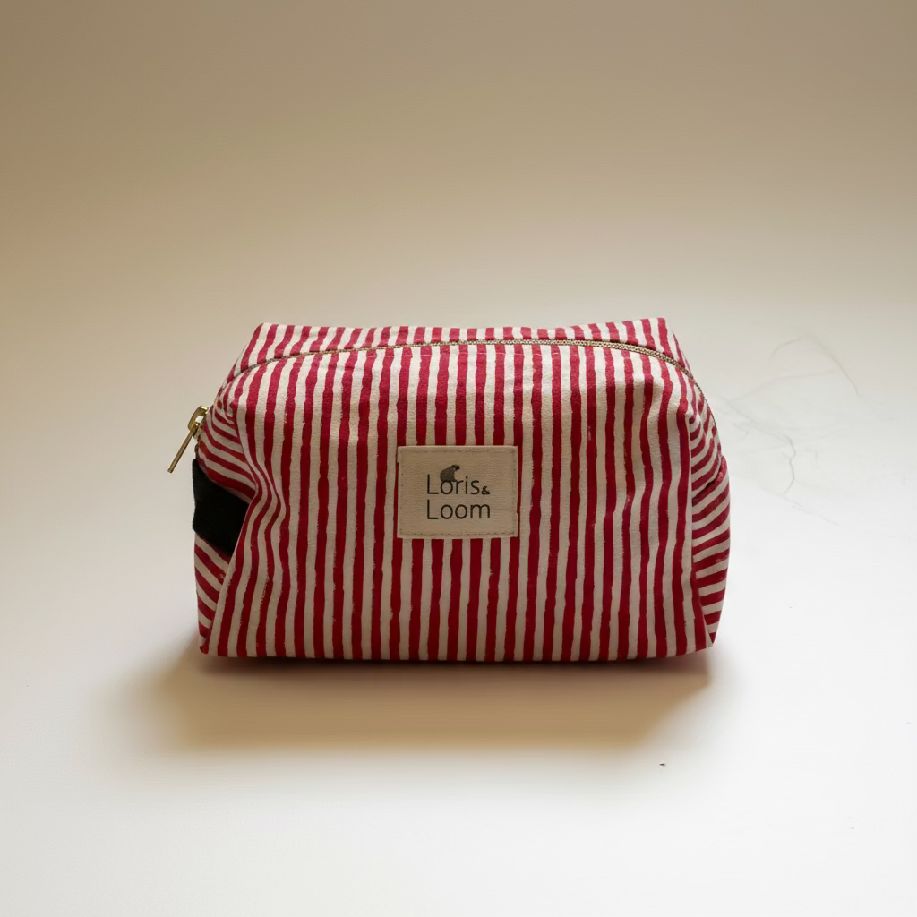 A red and white vertically striped fabric pouch with a silver zipper and a white label reading 'Loris and  Loom'.