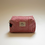 A red and white vertically striped fabric pouch with a silver zipper and a white label reading 'Loris and  Loom'.